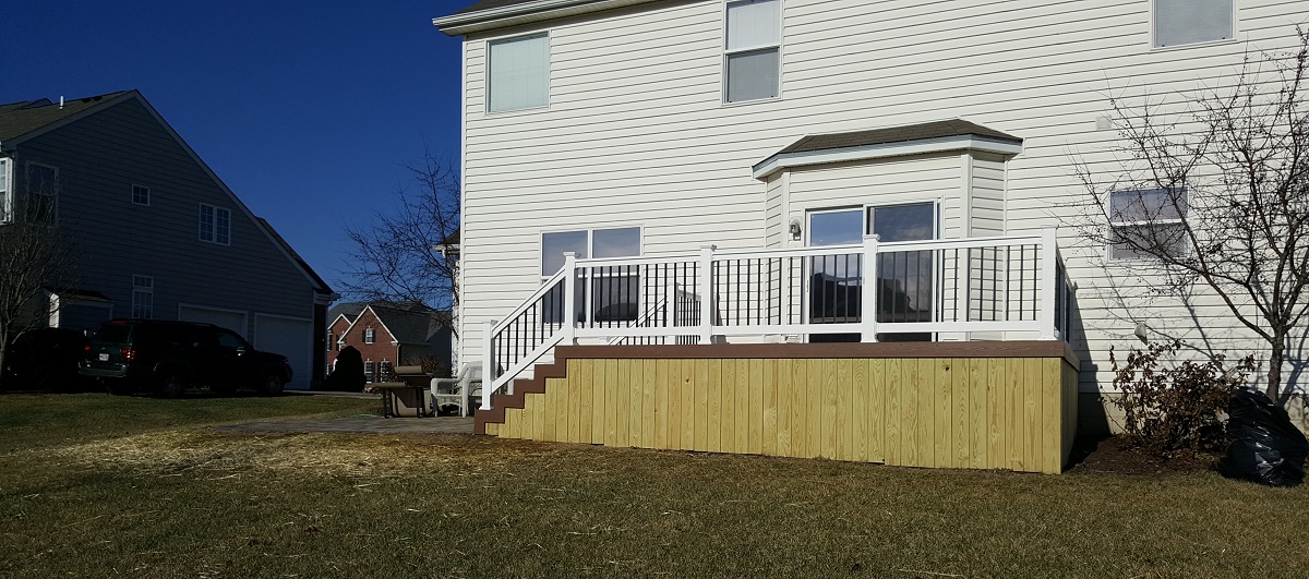 Low-maintenance deck with low-maintenance railing and pressure-treated wood skirting.
